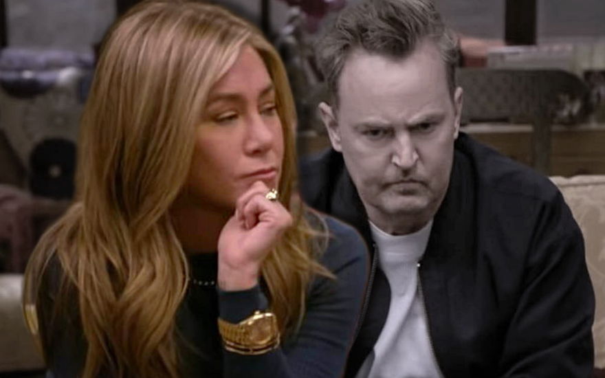 Jennifer Aniston sieht traurig zur Seite, hinter ihr sitzt ein ausgegrauter Matthew Perry, der frustriert aussieht