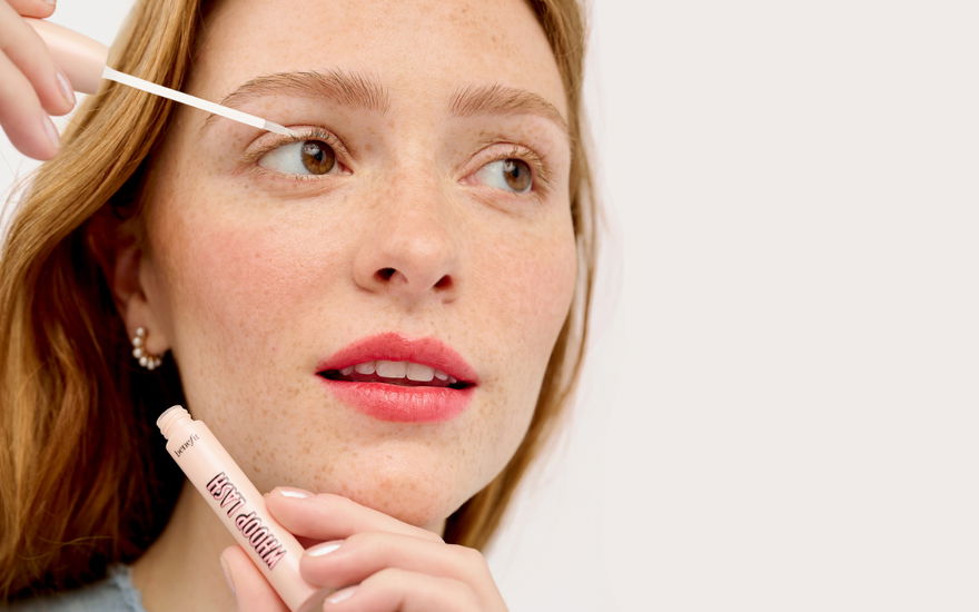 Frau benutzt wimpernserum von benefit