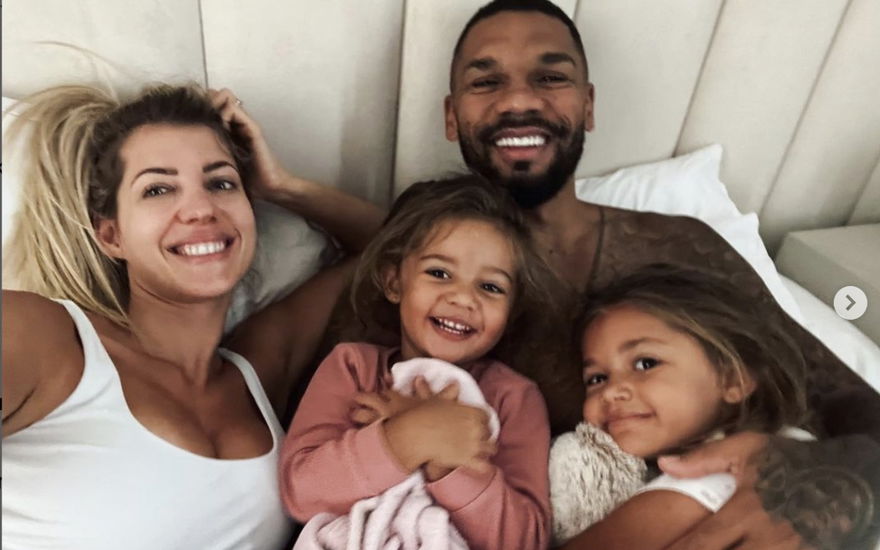 Sarah und Dominic Harrison lachen auf Selfie im Bett mit ihren Töchtern Mia Rose und Kyla