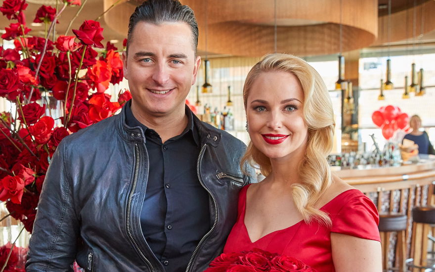 Andreas Gabalier und Silvia Schneider mit einem Strauß roter Rosen