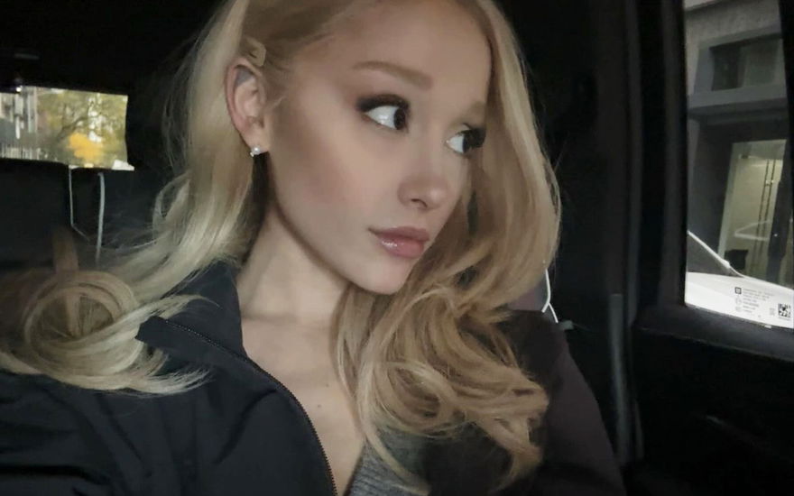 Ariana Grande macht ein Selfie im Auto und schaut gedankenverloren aus dem Fenster
