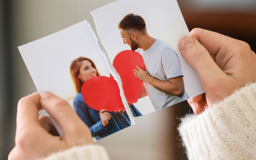 frau hält durchgerissenes bild von liebespaar in den händen