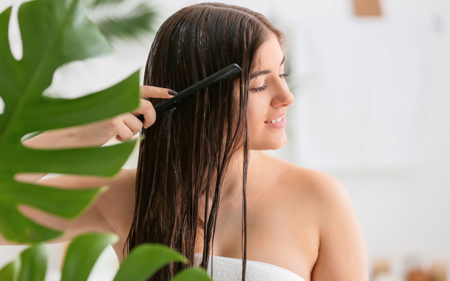 Frau kämmt nasse Haare
