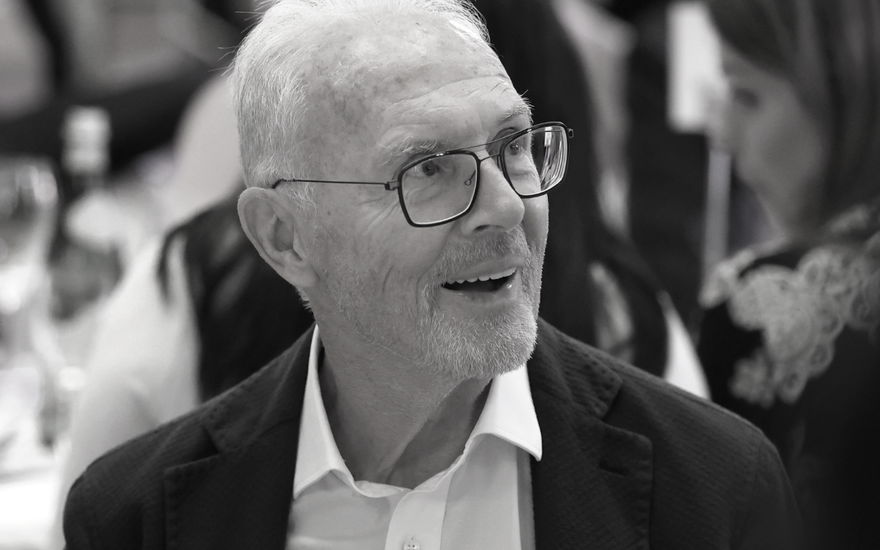 Franz Beckenbauer schaut lächelnd mit Brille zur Seite