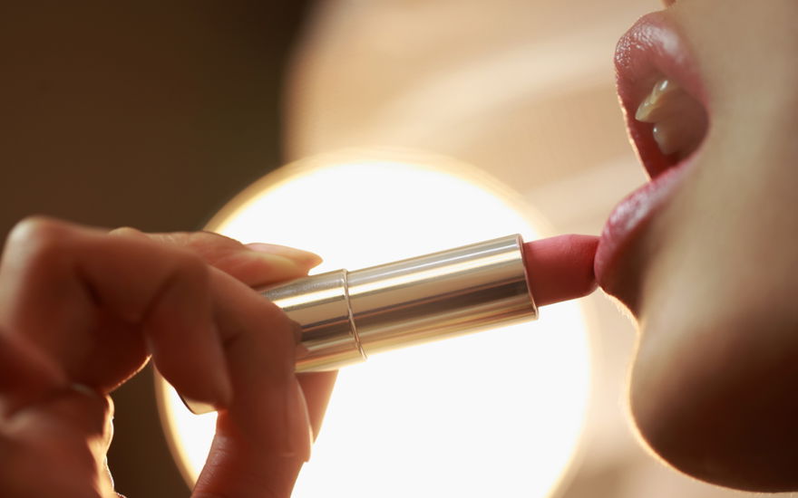 Frau trägt Lippenstift auf