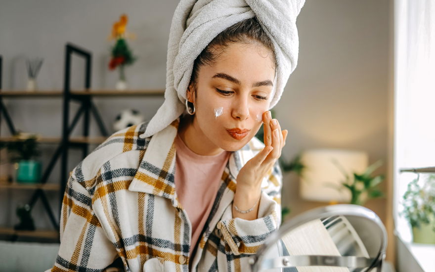 Frau verwendet Anti-Aging-Creme vor Kosmetikspiegel