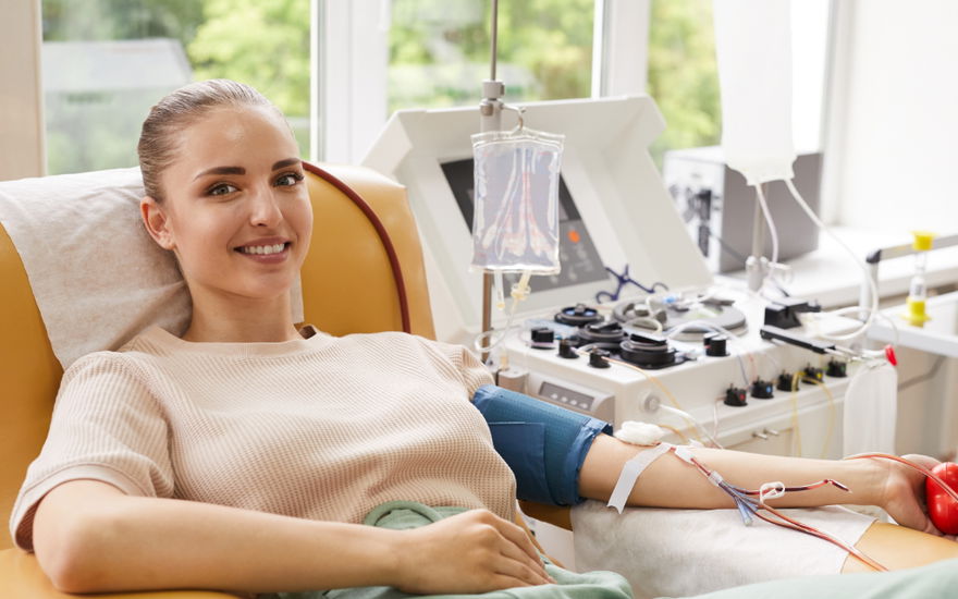 junge frau lächelt beim blut spenden