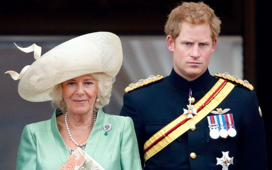 Königin Camilla und Prinz Harry stehen mit ernsten Gesichtern nebeneinander