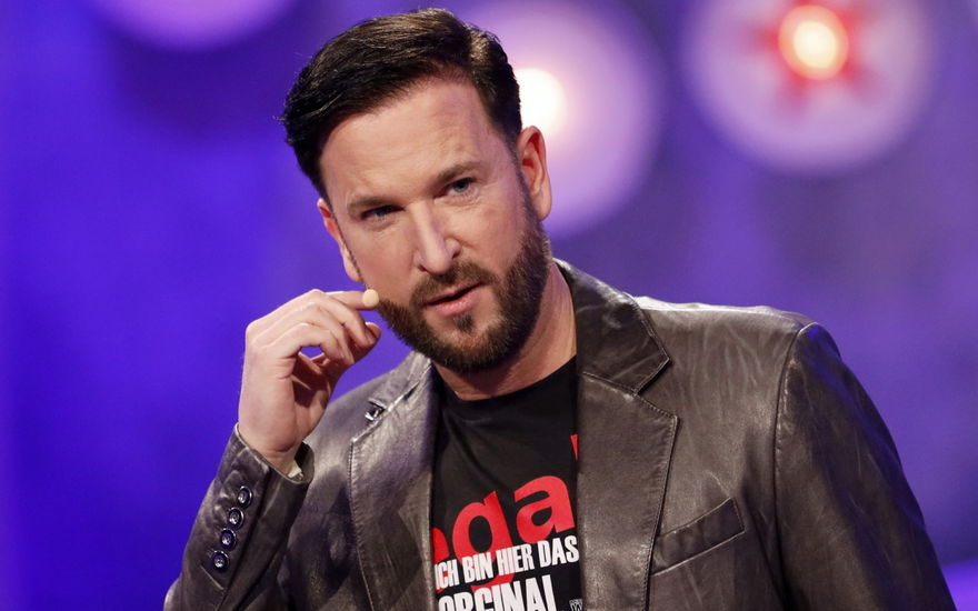 Michael Wendler greift sich an sein Mikrofon im Gesicht