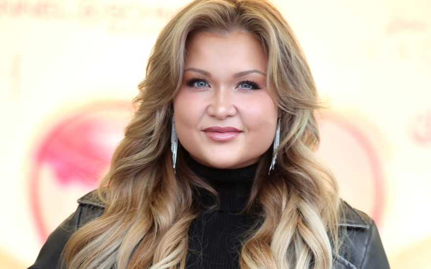 Sophia Thiel lächelt und trägt Ohrringe