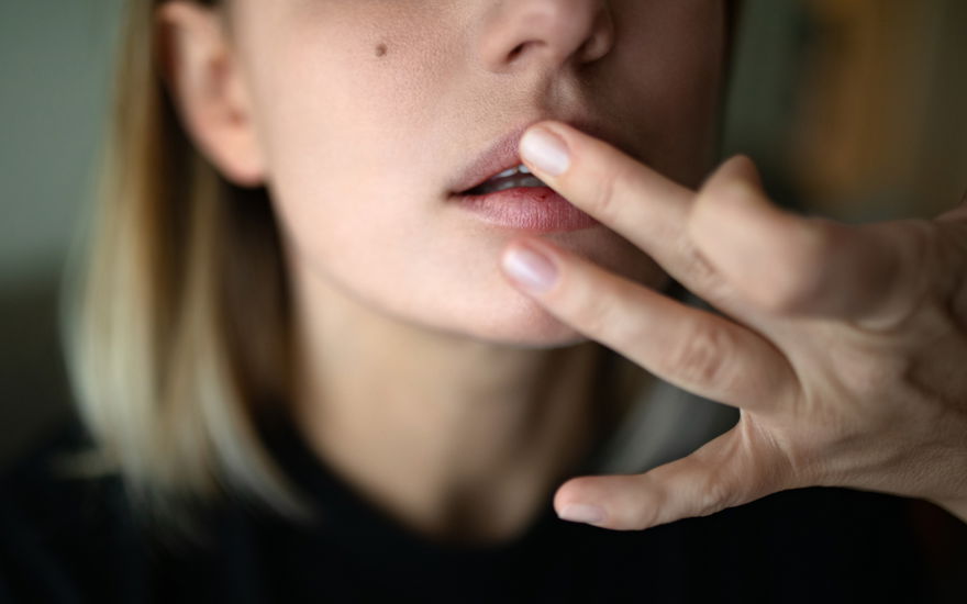 Frau pflegt Lippen mit Augencreme