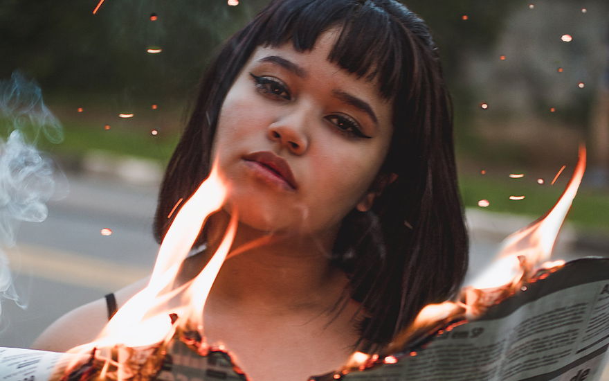 frau mit flammender Zeitung
