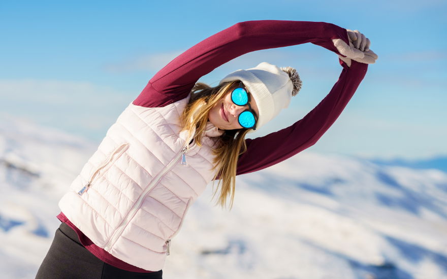 frau macht dehnübungen im schnee