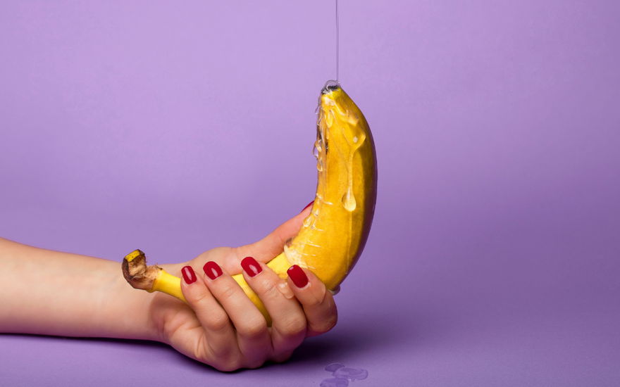 frau hält banane mit gleitgel in der hand