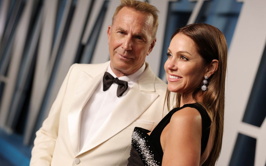 Kevin Costner wirkt verhalten, Christine Baumgartner lächelt. glücklich