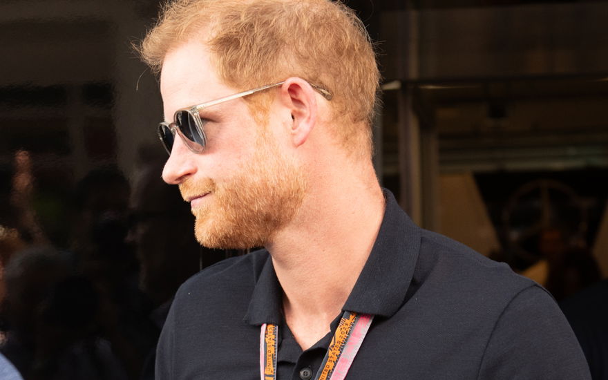 Prinz Harry von der Seite, er guckt ernst und trägt eine Sonnenbrille