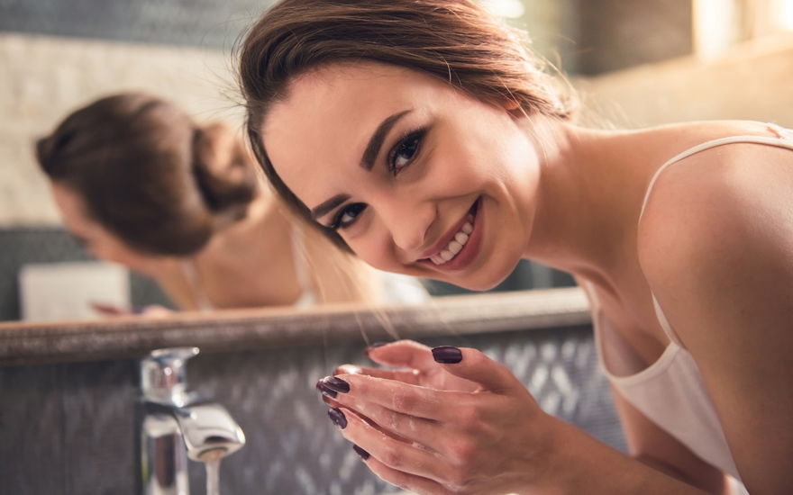 Frau wäscht Gesicht mit Cleanser