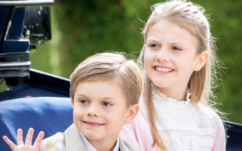 Prinz Oscar und Prinzessin Estelle von Schweden winken und lächeln.