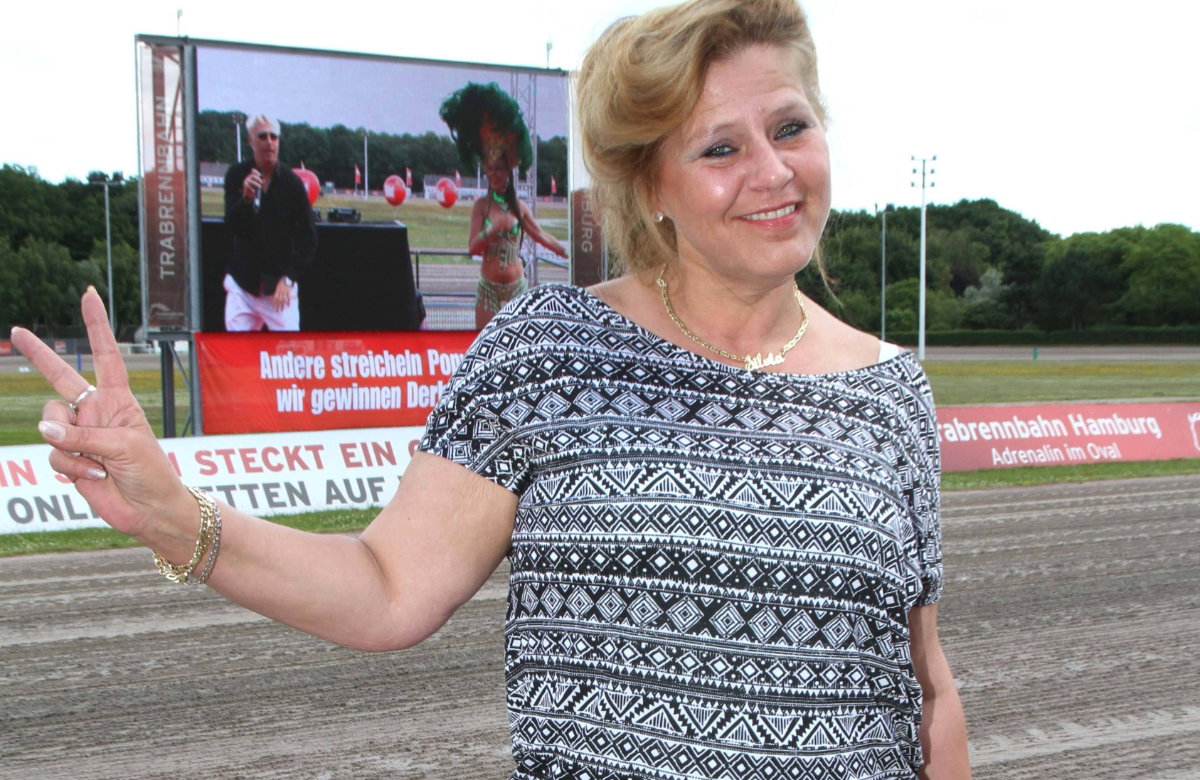 Silvia Wollny lächelt und zeigt mit den Fingern Peace