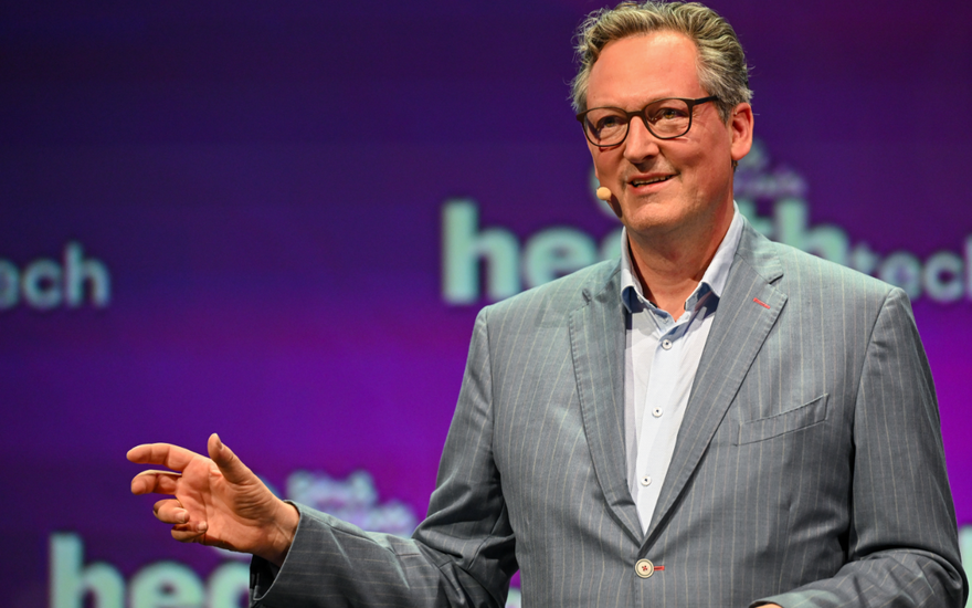 Eckart von Hirschhausen guckt ernst mit Mikro an der Wange