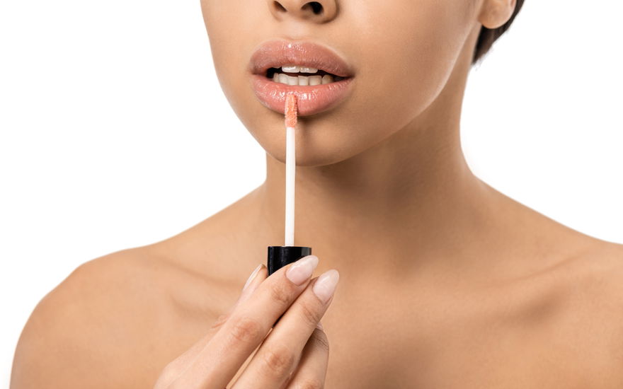 Frau mit Lipgloss für volle Lippen