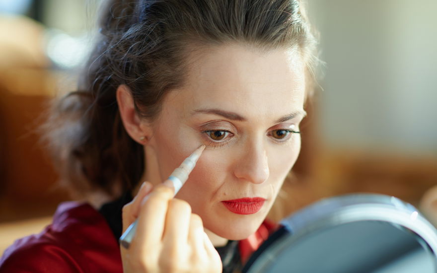 Frau mit Concealer Stick