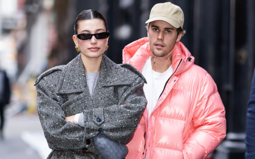 Hailey Bieber verschränkt die Arme, Justin Bieber läuft mit genervtem Gesichtsausdruck hinter ihr
