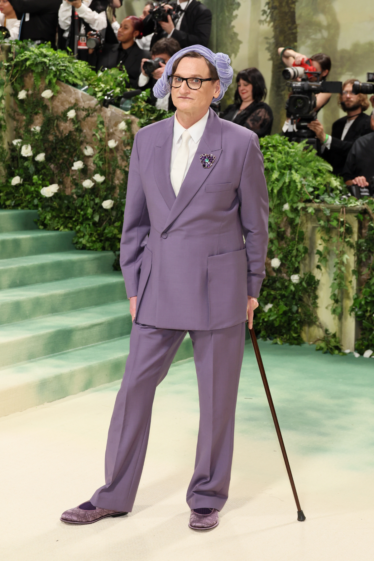 Hamish Bowles im lilanen Anzug mit lilanem Hut auf dem Kopf bei der MET Gala 2024