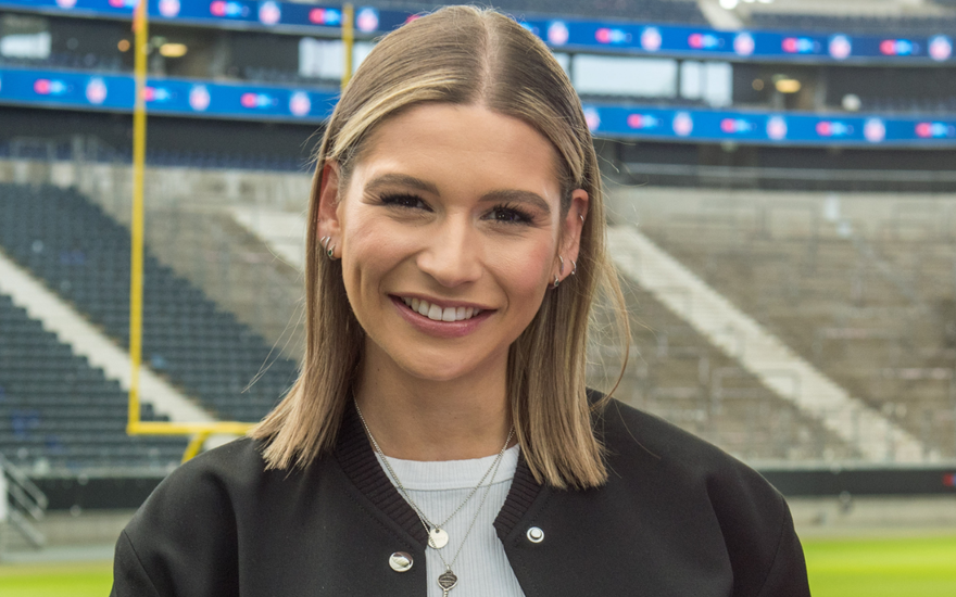 Jana Wosnitza lächelt, Stadion im Hintergrund