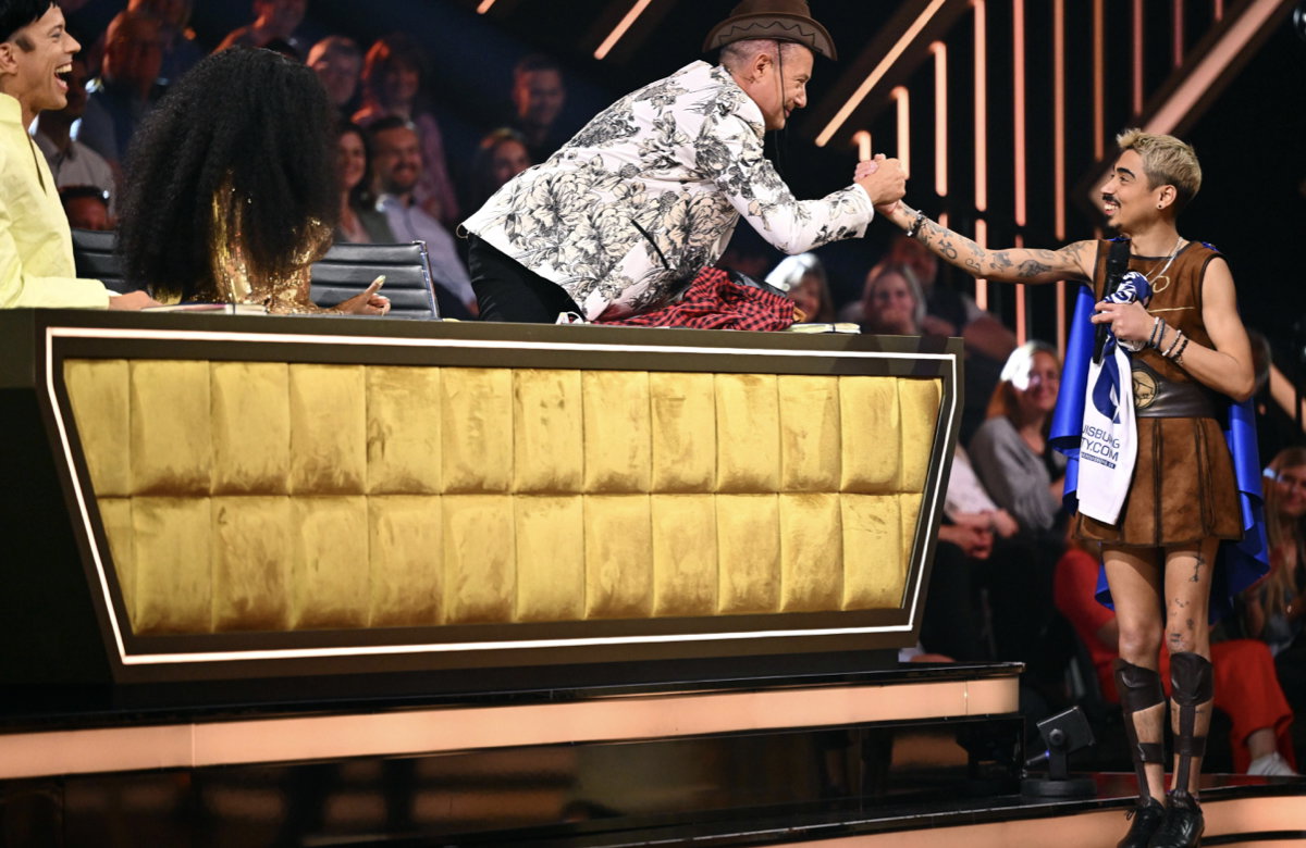 Joachim Llmabi und Tony Bauer geben sich die Hand und lächeln.
