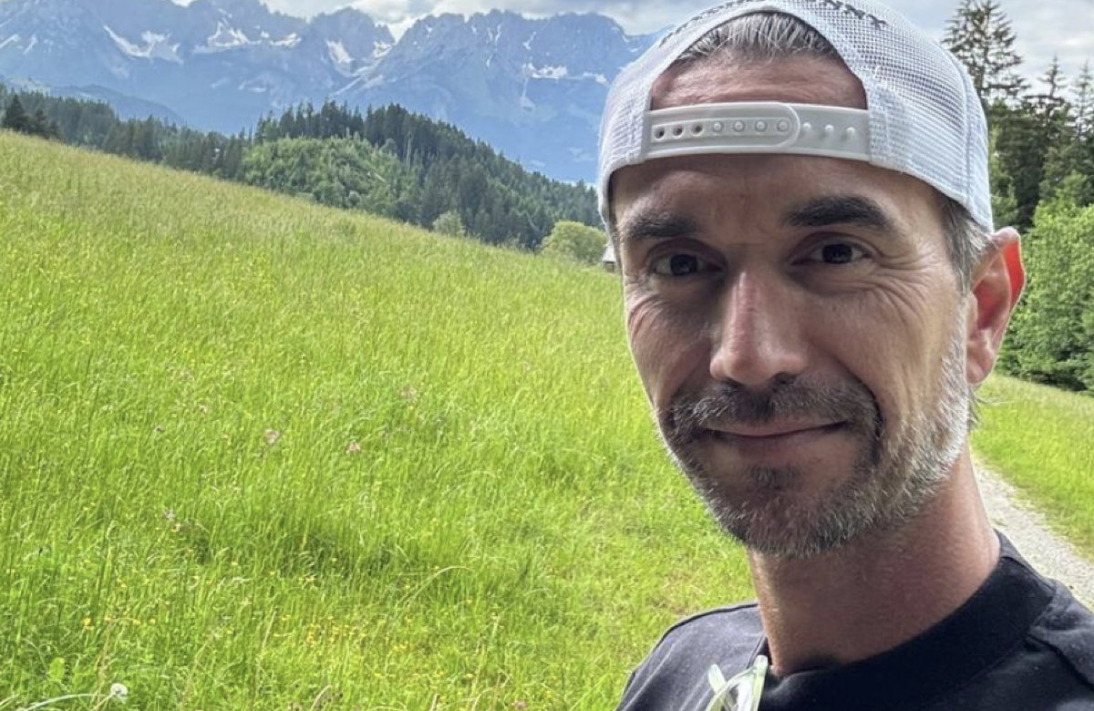 Florian Silbereisen deutet bei einem Selfie in den Bergen ein Lächeln an.