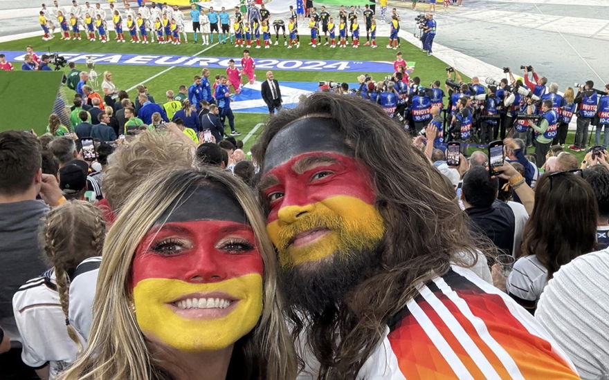 Heidi Klum und Tom Kaulitz lächeln beim EM-Anpfiff in die Kamera