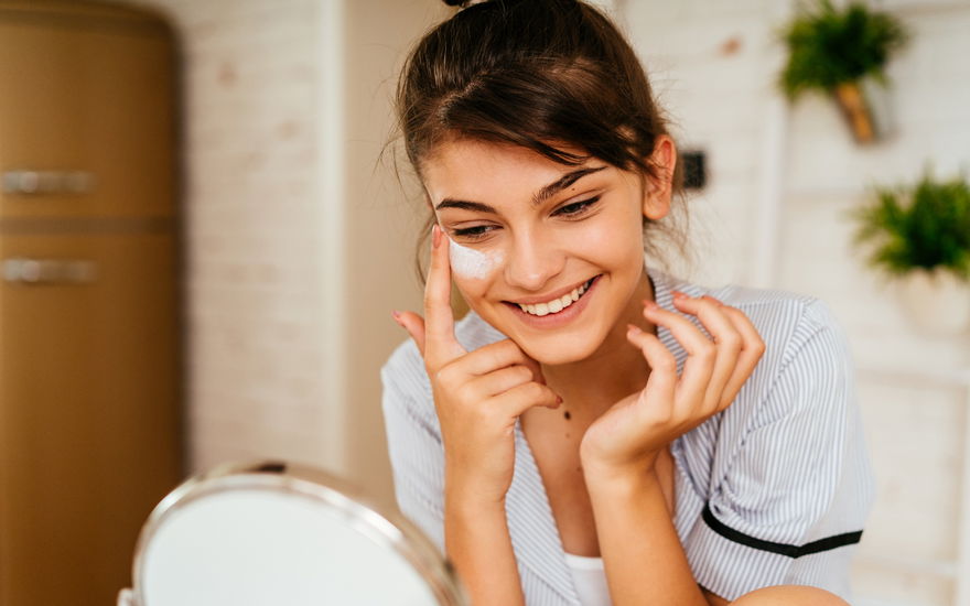 Frau cremt Anti-Aging-Pflege auf