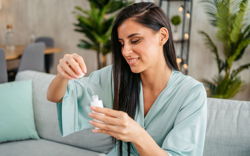 Frau sitzt mit Serum auf Couch