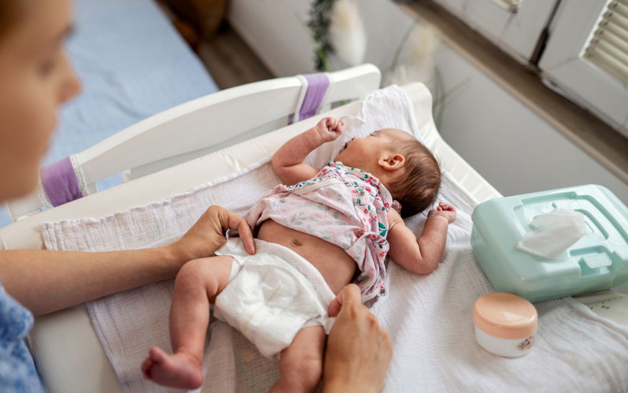 Baby wird gewickelt, Feuchttücher in der Ecke