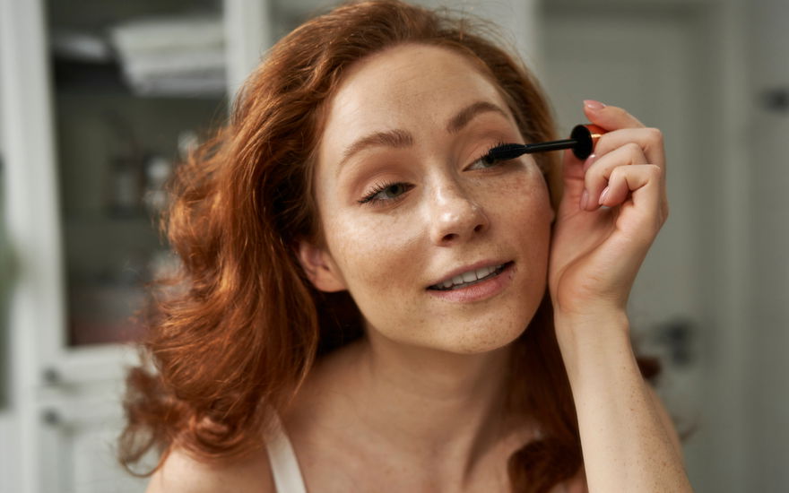 Frau tuscht sich die Wimpern