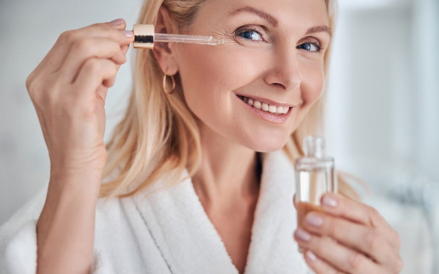 Frau Ü50 trägt Anti-Aging-Serum auf
