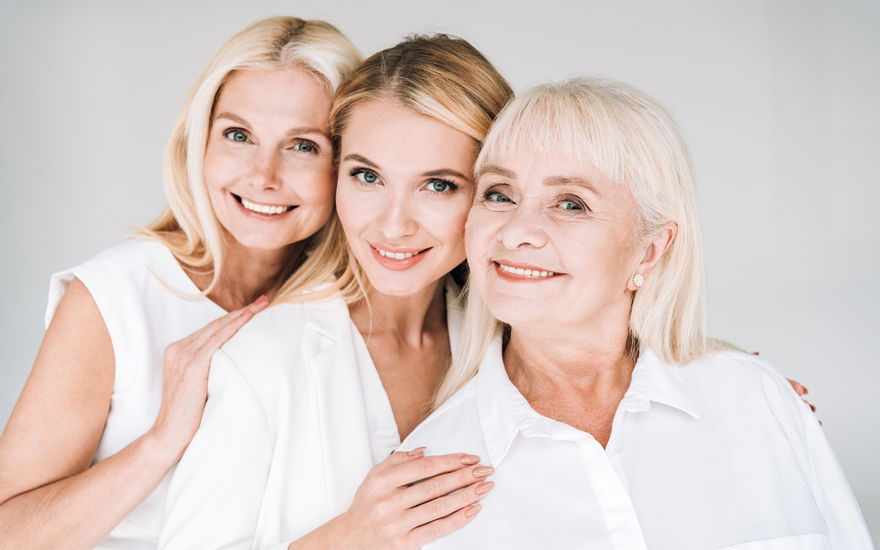 Fröhliche drei Generation blonde Frauen isoliert auf grau