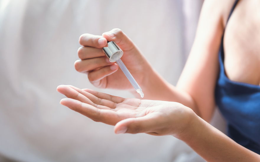 Frau gibt Serum in die Hand