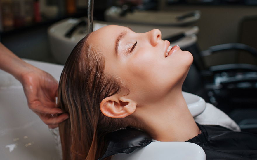 Frau im Friseurwaschbecken