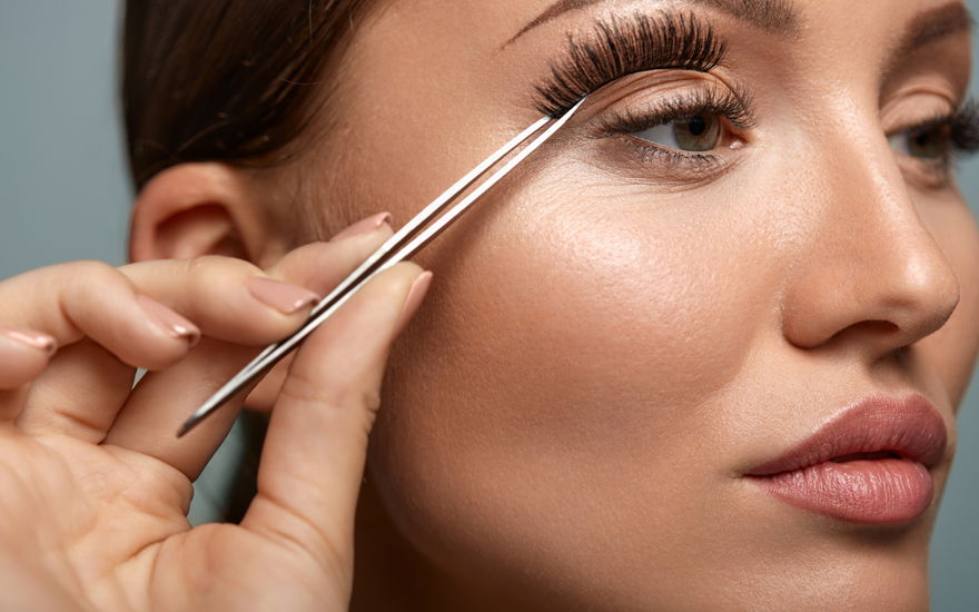 Frau klebt Wimpern an