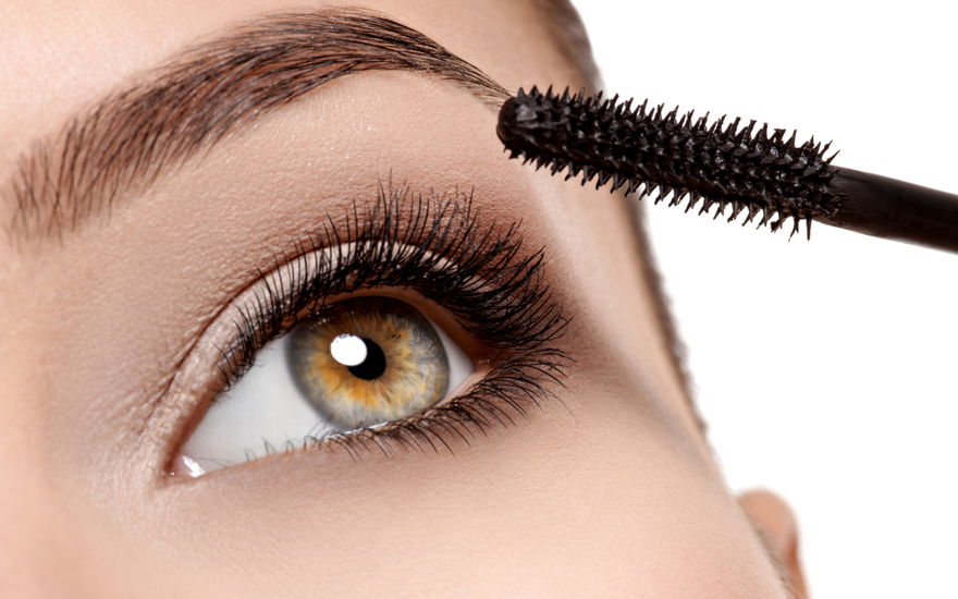 Frau tuscht Wimpern