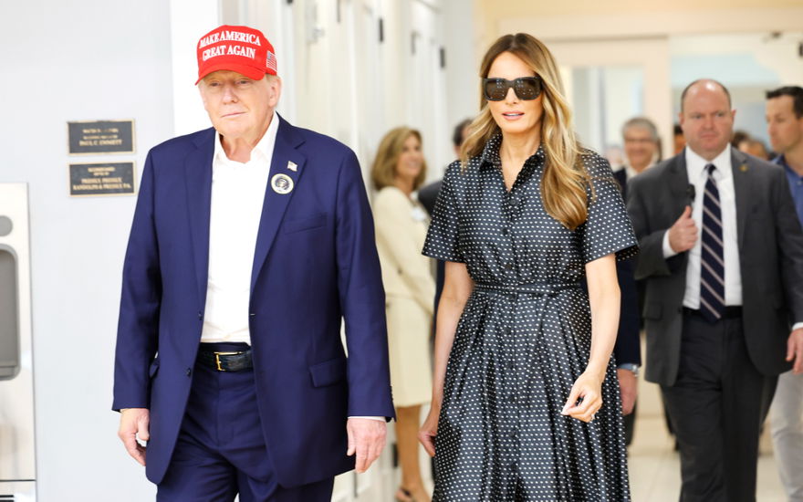 Donald & Melania Trump gehen nebeneinander, Menschen im Hintergrund