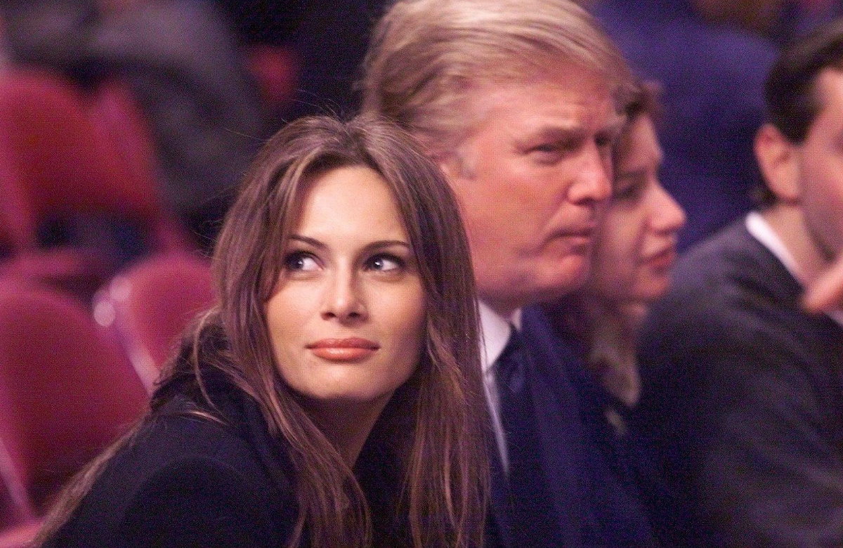 Melania Trump schaut zur Seite, Donald im Hintergrund