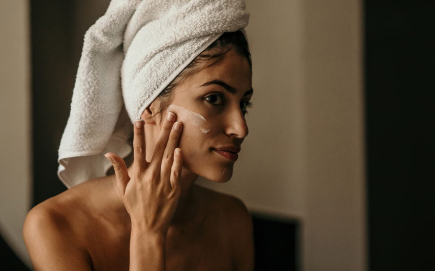 Anti-Aging-Creme vor Spiegel auftragen