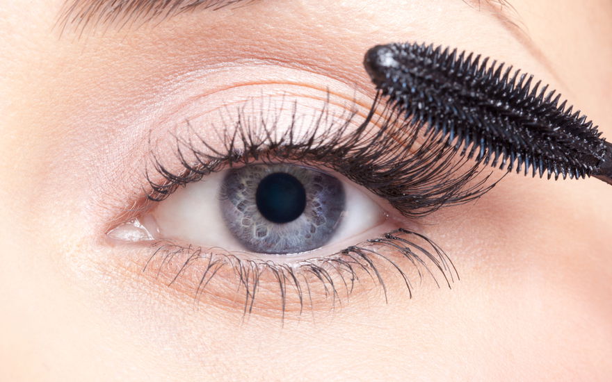 Frau tuscht Wimpern