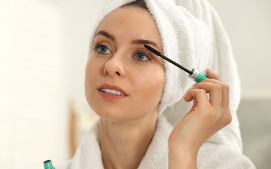 Frau tuscht Wimpern