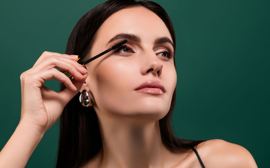 Frau tuscht Wimpern an