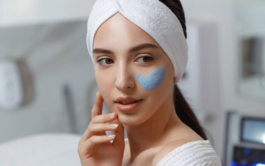 Frau blaues Peeling im Gesicht