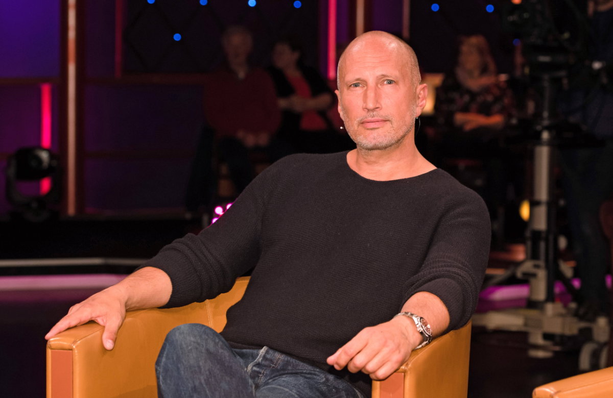 Benno Fürmann sitzt auf einem Sofa
